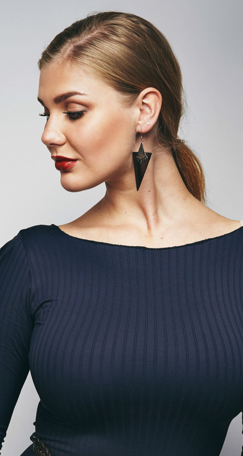 Model showcasing elegant earrings and stylish outfit.