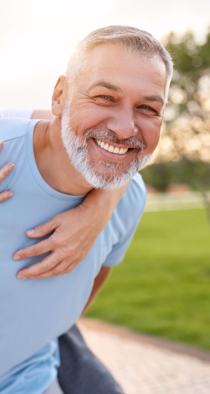 Smiling man outdoors with happy embrace.