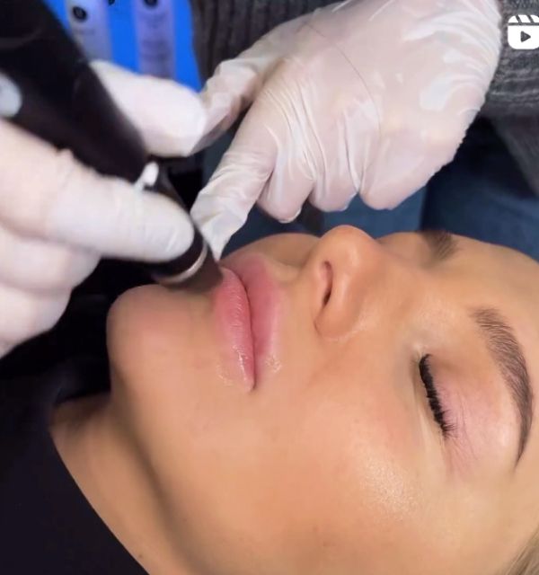 Applying cosmetic treatment to woman's lips.