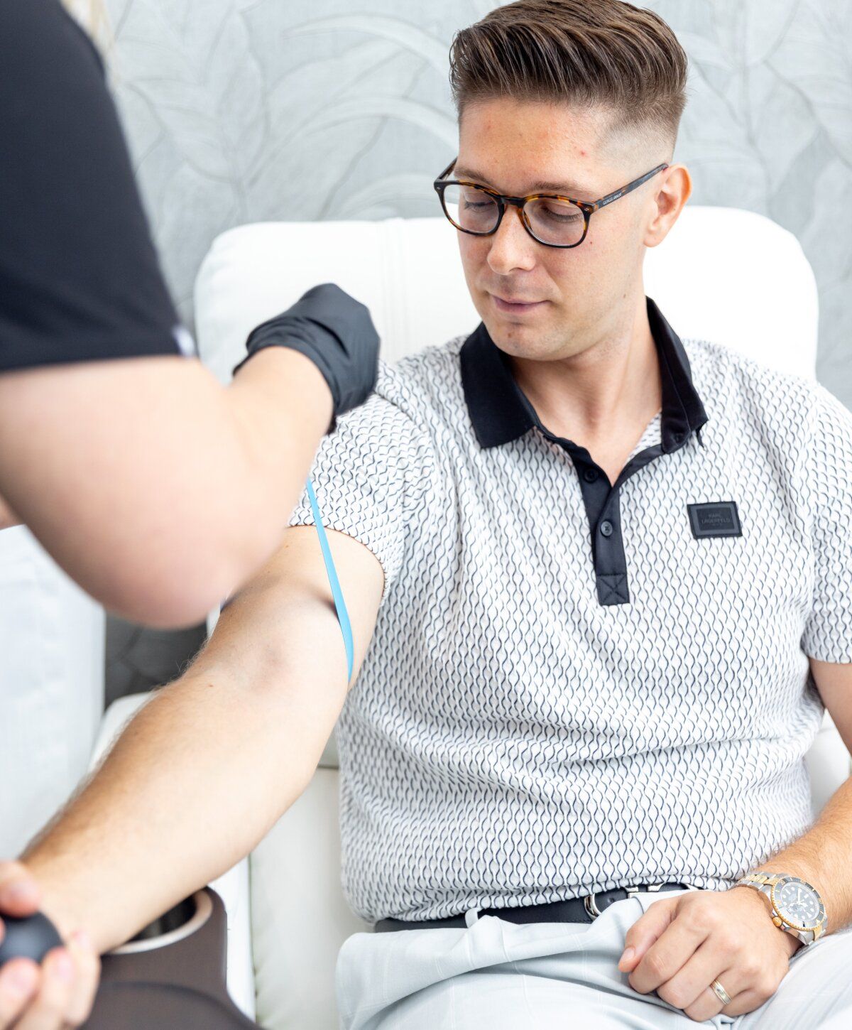 iv therapy patient model getting his arm prepped for treatment
