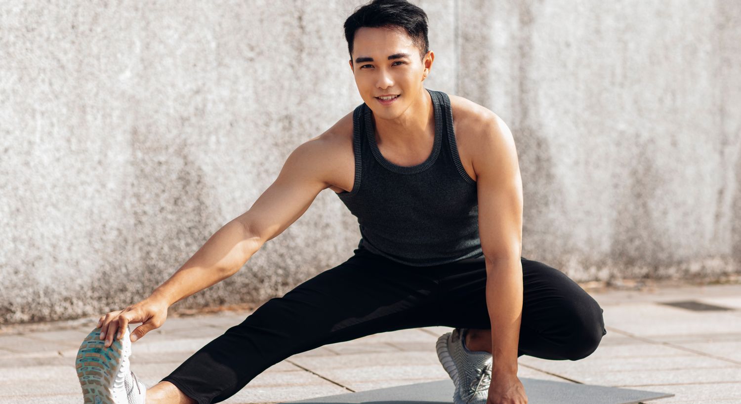 CJC 1295 peptide therapy patient model stretching outside. in a black tank top and pants